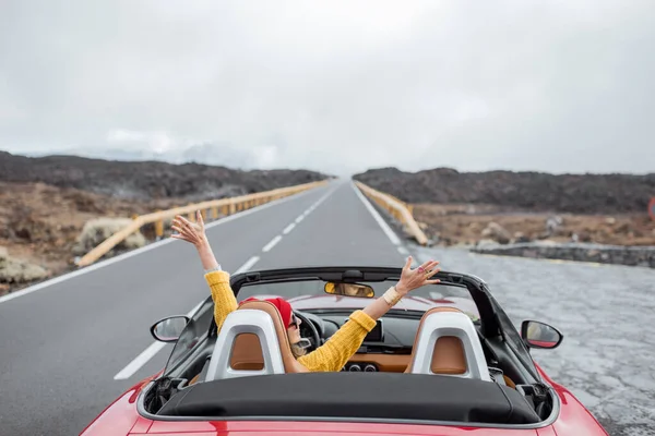 Kvinna som reser med cabriolet bil på vulkaniska dalen — Stockfoto