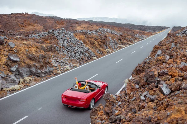 Mujer conduciendo cabriolet rojo en el valle volcánico — Foto de Stock