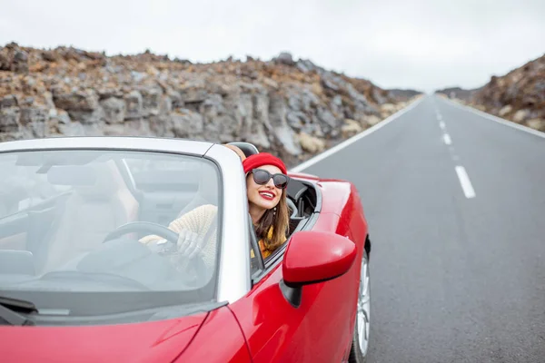 Kobieta podróżująca kabrioletem na wulkanicznej dolinie — Zdjęcie stockowe