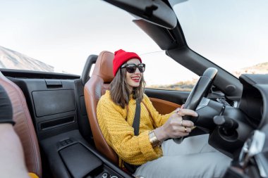 Çölde Cabriolet arabasıyla seyahat eden bir kadın.