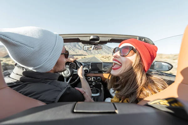 Bir çift seyahat ederken araba kullanıyor.