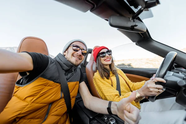 Casal feliz dirigindo um cabriolet enquanto viaja — Fotografia de Stock