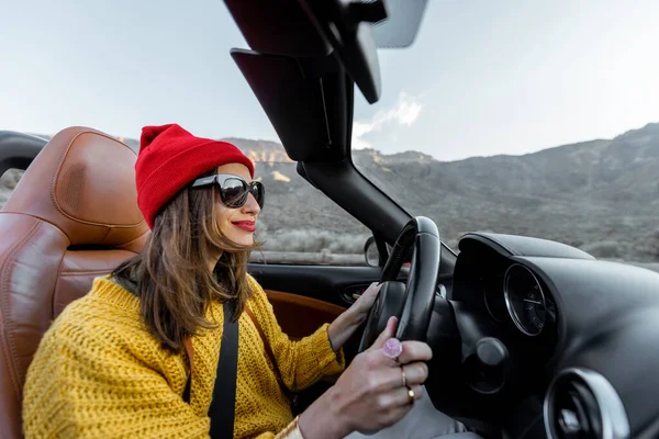 Woman traveling by cabriolet car on the desert road — Stock Photo, Image