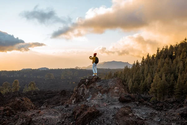 Vrouw op het vulkanische land op een zonsondergang — Stockfoto