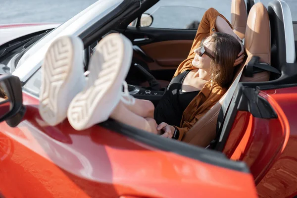 ผู้หญิงเพลิดเพลินกับวันหยุดฤดูร้อนขณะเดินทางโดยรถยนต์ — ภาพถ่ายสต็อก