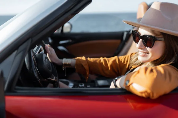 Mujer conduciendo un cabriolet cerca del océano — Foto de Stock