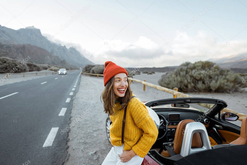 Portrait of a joyful woman enjoying road trip in nature