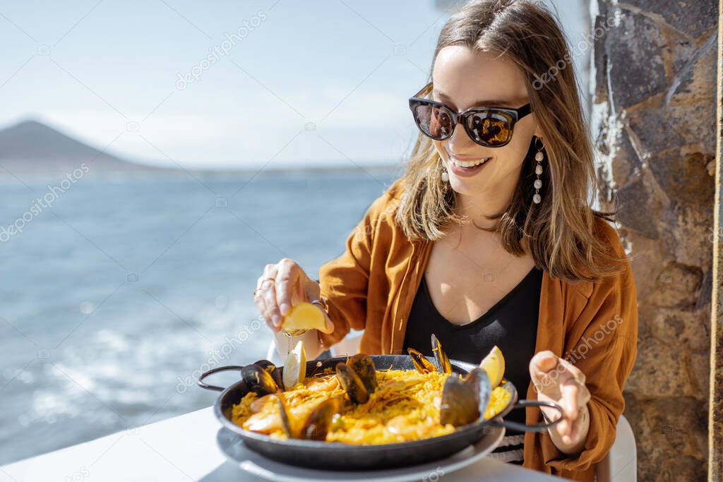 Woman eating sea food near the ocean