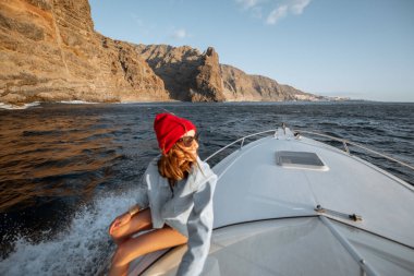 Kayalık kıyılarda yelken açan bir kadın