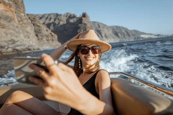 Расслабленная женщина, плывущая на яхте у скалистого берега — стоковое фото