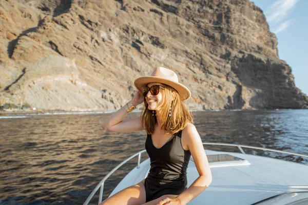Жінка плаває на яхті біля скелястого узбережжя — стокове фото