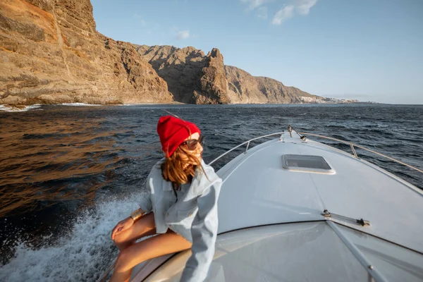 Frau segelt in der Nähe der felsigen Küste — Stockfoto
