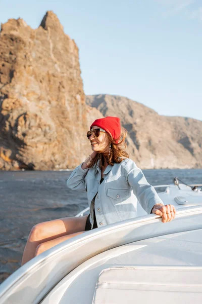 Mulher navegando no iate perto da costa rochosa — Fotografia de Stock