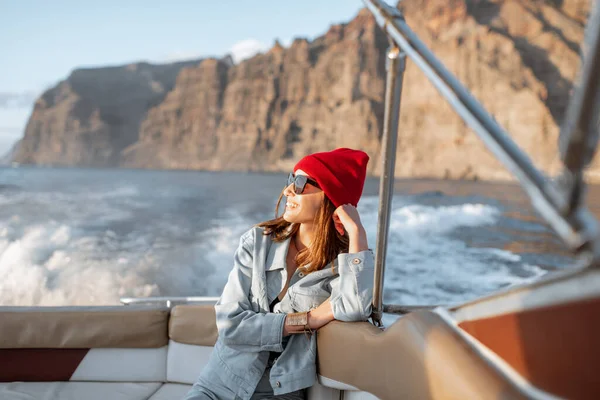 Mujer viajando en un yate cerca de la costa rocosa — Foto de Stock