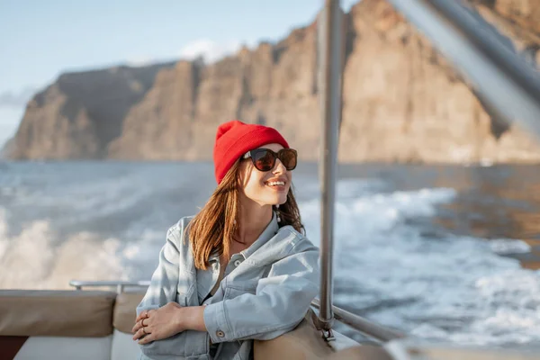Woman traveling on a yacht near the rocky coast