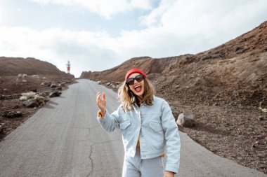 Genç bir kadın kayalık arazilerde seyahat ediyor.