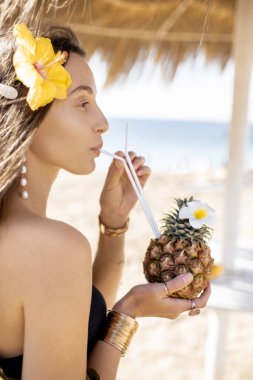 Plaj merkezinde egzotik kokteyli olan bir kadın.