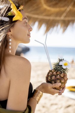 Plaj merkezinde egzotik kokteyli olan bir kadın.