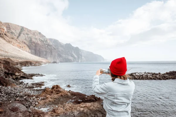 Mujer viajando en la costa rocosa del océano — Foto de Stock