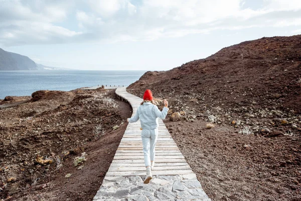 Mujer corriendo por el hermoso sendero ondulado cerca del océano — Foto de Stock