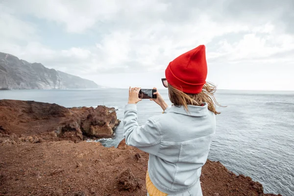 Женщина, путешествующая по скалистому океану — стоковое фото