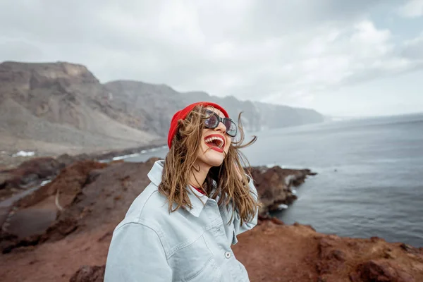 Mujer viajando en la costa rocosa del océano — Foto de Stock