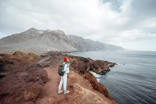 Mujer viajando en la costa rocosa del océano en la isla —  Fotos de Stock