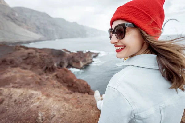 Mujer viajando en la costa rocosa del océano — Foto de Stock