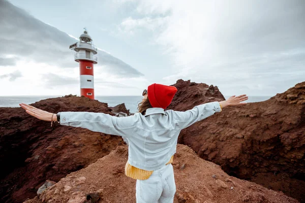 Mujer viajando por los paisajes rocosos cerca del faro — Foto de Stock