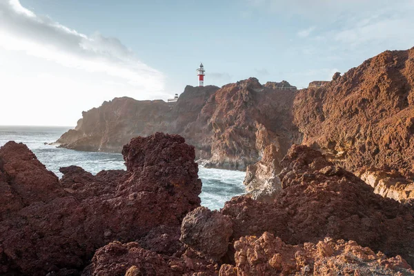 Rocky pantai laut dengan mercusuar pada matahari terbenam — Stok Foto