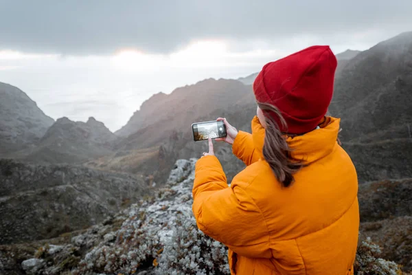 Vrouw fotografeert bergen tijdens het reizen — Stockfoto