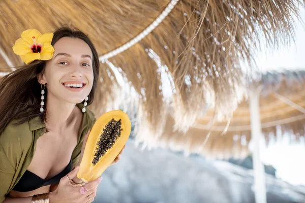 Жінка з папайя фруктами на пляжі — стокове фото