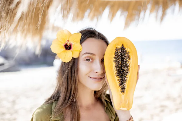 Літня дівчина з папайя фруктами на пляжі — стокове фото