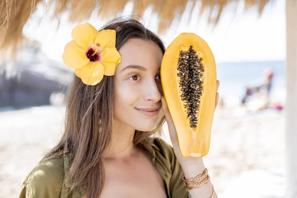 Літня дівчина з папайя фруктами на пляжі — стокове фото