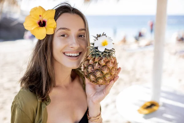 Summer girl with pineapple fruit at the beach resort — Stockfoto