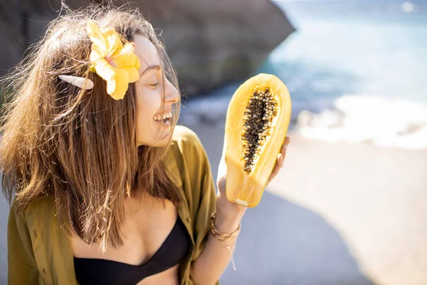 Літня дівчина з екзотичними фруктами на пляжі — стокове фото