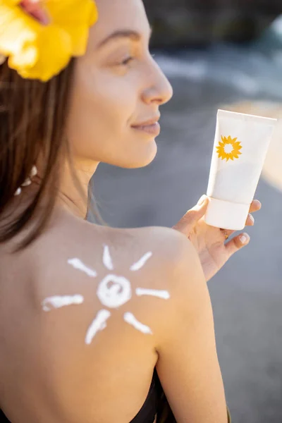 Mulher com protetor solar loção na praia — Fotografia de Stock