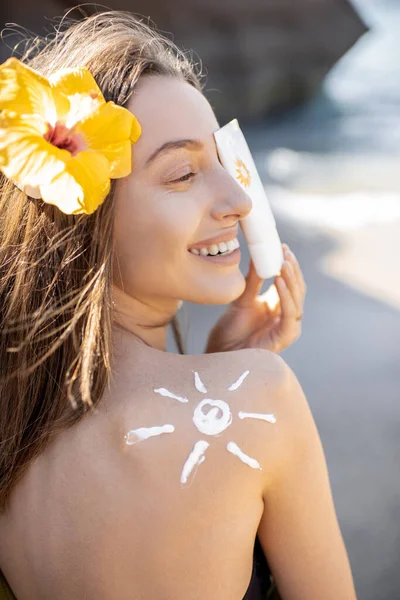 Donna con crema solare lozione sulla spiaggia — Foto Stock