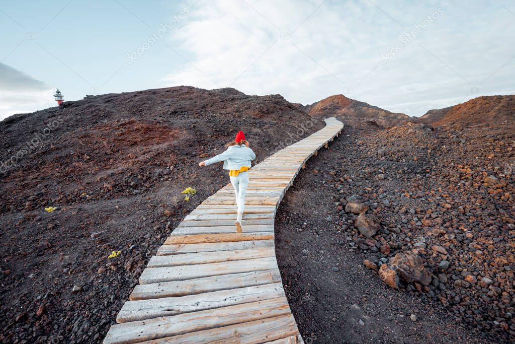 Woman on the boardwalk through the rocky land