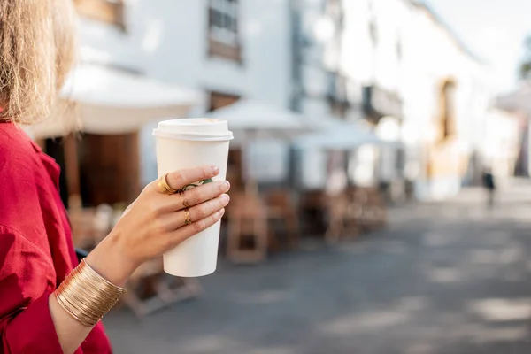 Holding paper cup with coffee to go outdoors