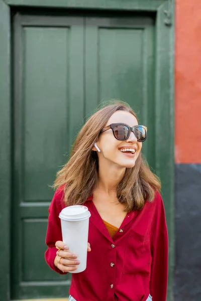 Стильна жінка з кавою на зеленому фоні — стокове фото