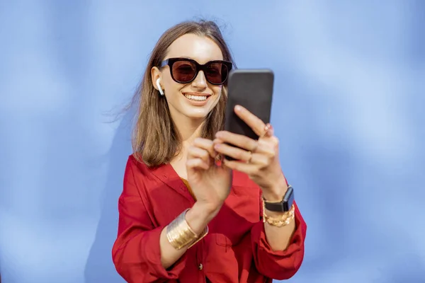 Mujer con teléfono en el fondo de color al aire libre — Foto de Stock