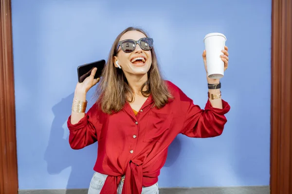 Стильна жінка з кавою на кольоровому тлі стіни — стокове фото