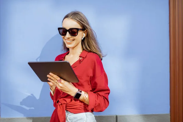 Frau mit digitalem Tablet auf dem Farbwandhintergrund — Stockfoto