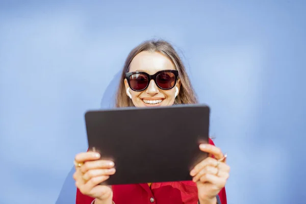 Vrouw met digitale tablet op de achtergrond van de kleurenmuur — Stockfoto