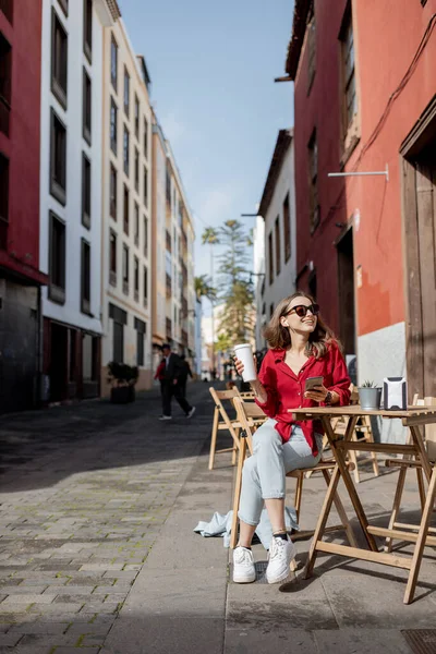 Mujer con teléfono y café en la terraza del café al aire libre —  Fotos de Stock
