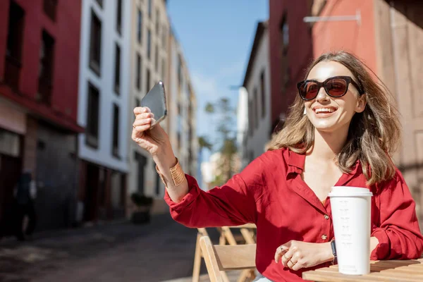 Mujer con teléfono y café en la terraza del café al aire libre —  Fotos de Stock