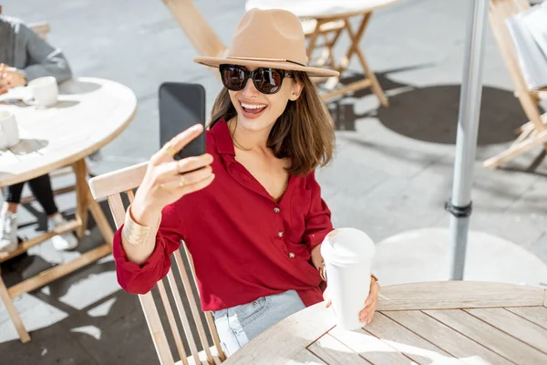 Mujer con teléfono móvil y café en la terraza del café —  Fotos de Stock