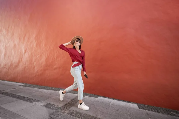Porträtt av en snygg kvinna på den röda väggen bakgrund — Stockfoto