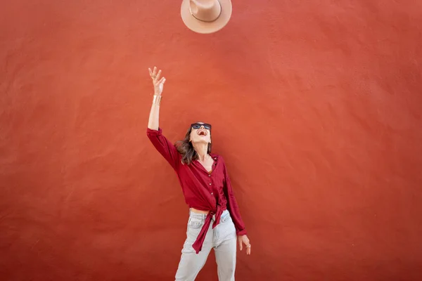 Portrait of a stylish woman on the red wall background — Stock Photo, Image